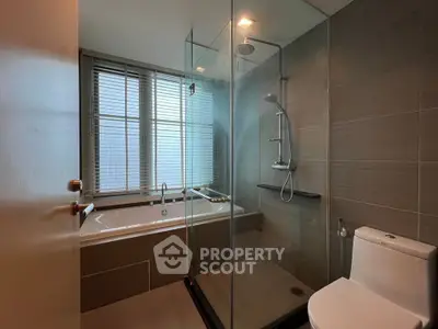 Modern bathroom with glass shower and bathtub in luxury apartment