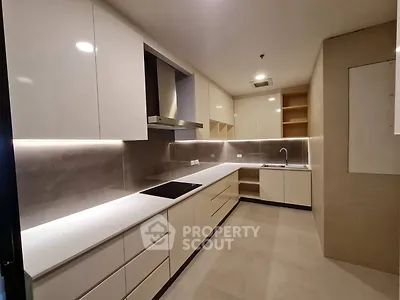 Modern kitchen with sleek cabinetry and built-in appliances in a contemporary apartment.