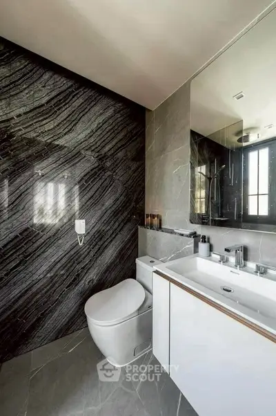 Luxurious modern bathroom with sleek design and elegant marble wall.