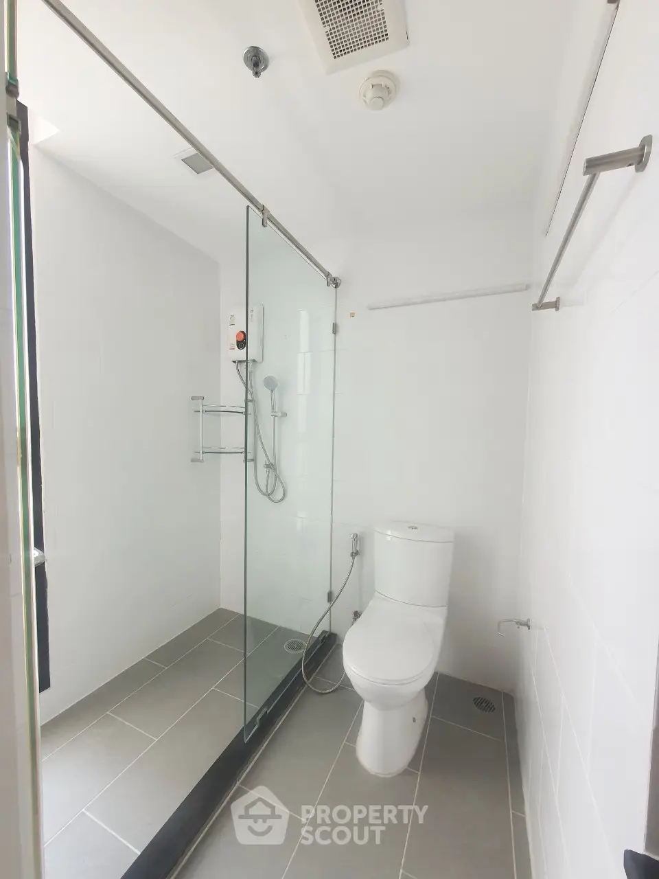 Modern bathroom with glass shower enclosure and sleek fixtures in a bright, minimalist design.
