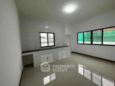 Spacious kitchen with modern design and large windows for natural light.