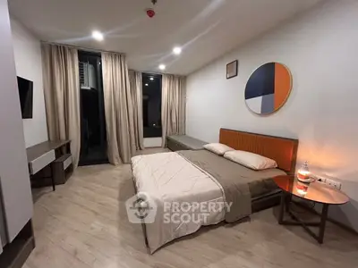 Modern bedroom with stylish decor and cozy lighting, featuring a comfortable bed and sleek furniture.
