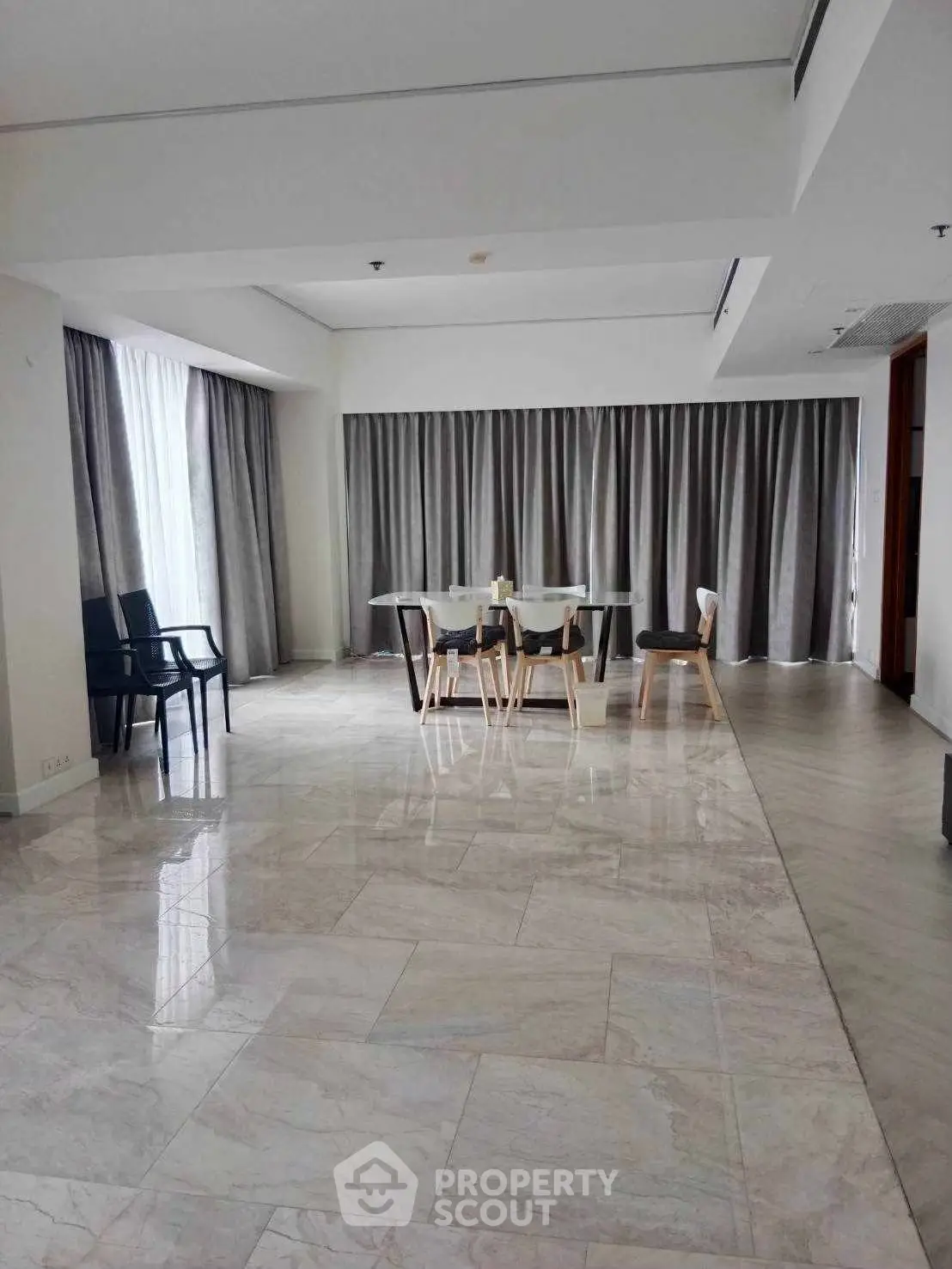 Spacious modern living room with elegant marble flooring and stylish dining area.