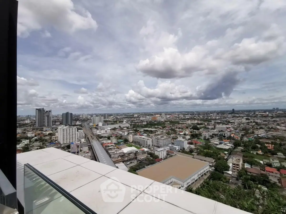 Stunning cityscape view from high-rise balcony with expansive skyline and clouds