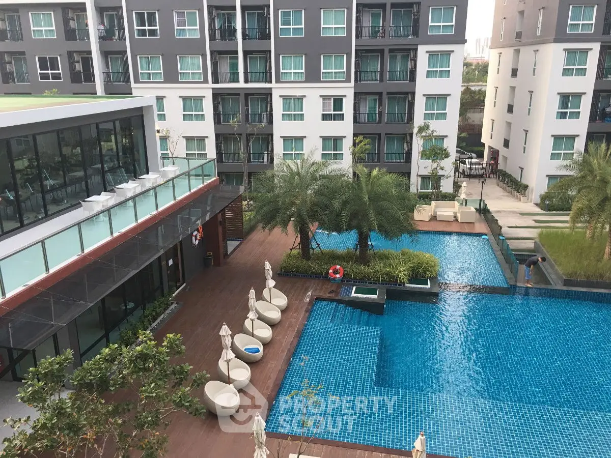 Modern apartment complex with pool and lush landscaping