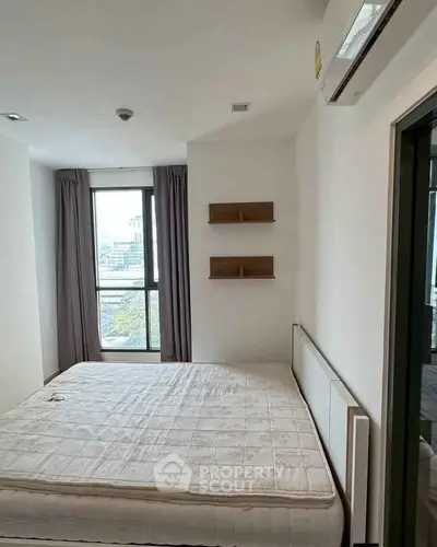 Modern bedroom with large window and city view, featuring minimalist decor and air conditioning.