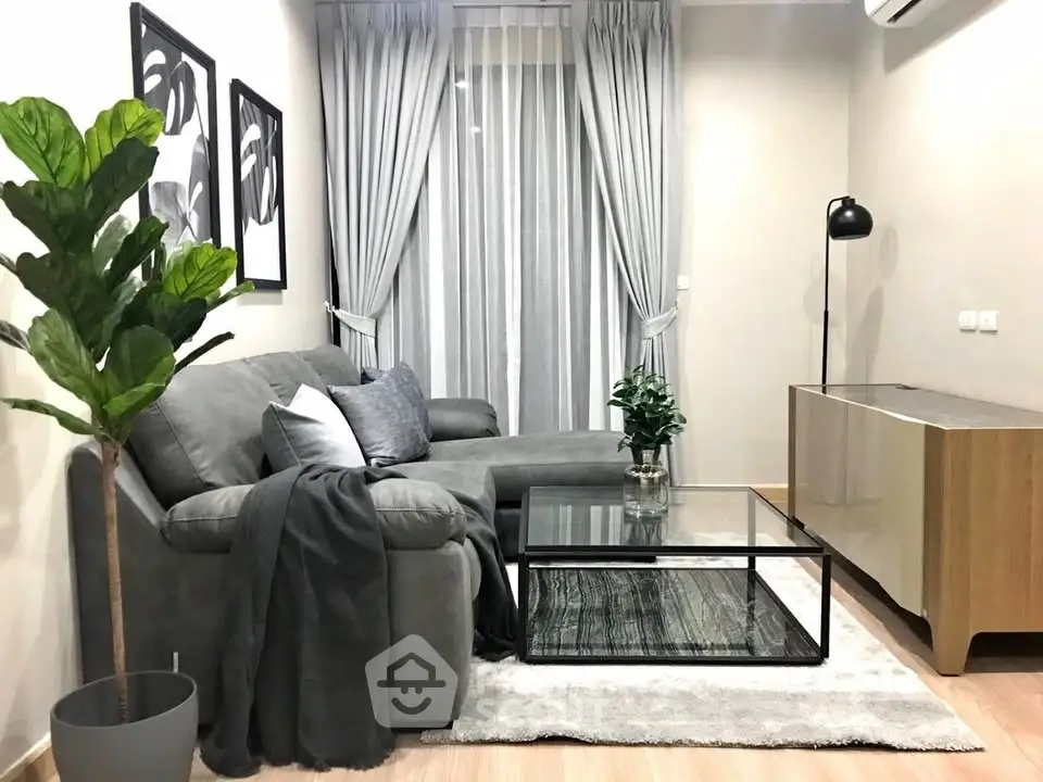 Modern living room with gray sectional sofa, glass coffee table, and stylish decor.