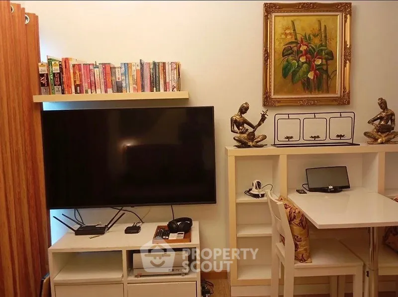 Cozy living room with TV, bookshelf, and elegant decor for a comfortable lifestyle.