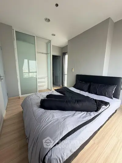 Modern bedroom with sleek design and large windows offering natural light.