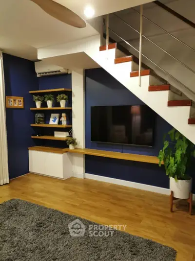 Modern living room with stylish staircase and wall-mounted TV