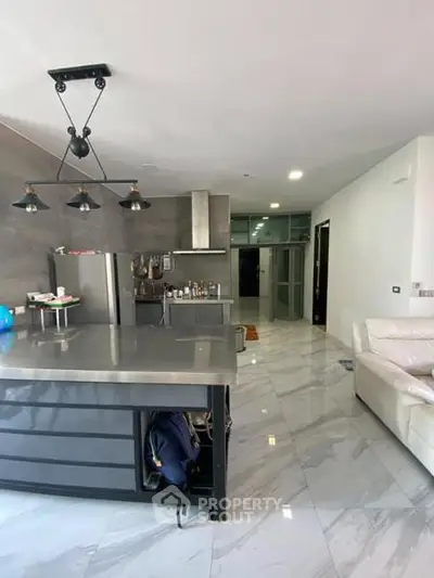 Modern kitchen with sleek design and open layout, featuring stainless steel appliances and elegant lighting.