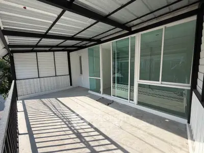Spacious covered balcony with sliding glass doors and modern design.