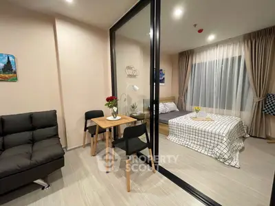Modern studio apartment with glass partition, cozy bed, and stylish decor.
