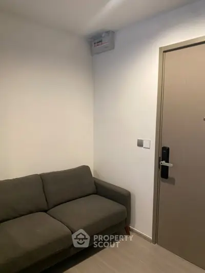 Cozy living room corner with modern sofa and secure door in a stylish apartment.