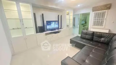 Modern living room with sleek black leather sofa and built-in entertainment center