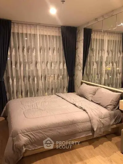 Cozy bedroom with elegant curtains and soft lighting, perfect for relaxation.