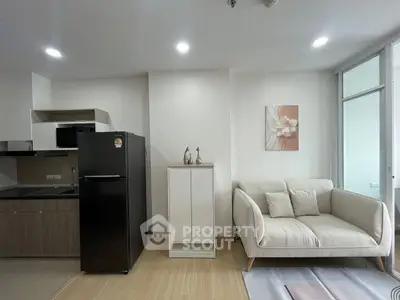 Modern apartment interior with sleek kitchen and cozy living area featuring a stylish sofa and decor.