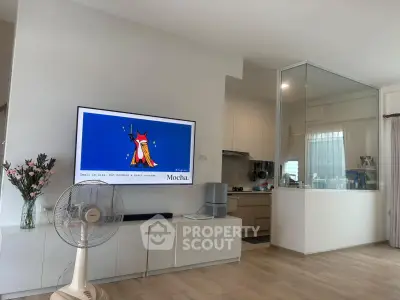 Modern living room with sleek TV setup and open kitchen design