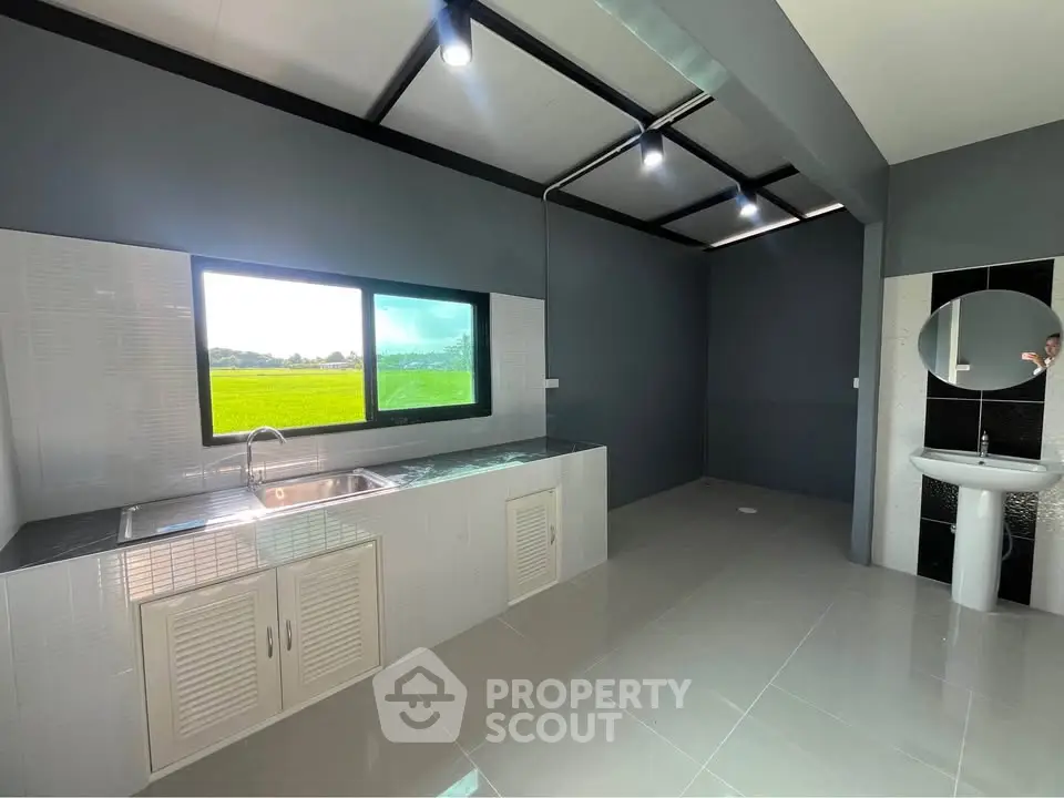 Modern kitchen with sleek design and scenic window view in a contemporary home.