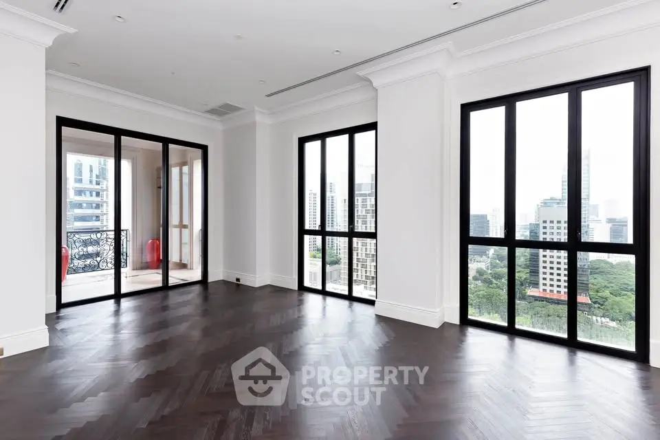Spacious corner unit with floor-to-ceiling windows offering a stunning city view and elegant dark wood flooring.