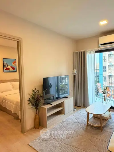 Modern living room with balcony view, stylish decor, and natural light in urban apartment.