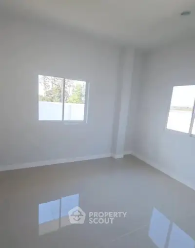Bright empty room with large windows and glossy tiled floor, perfect for customization.