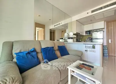 Modern open-layout living room with cozy sofa and stylish kitchen