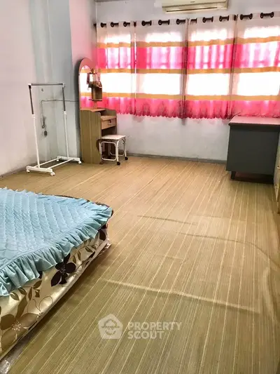 Spacious bedroom with natural light and simple furnishings, ideal for comfort and relaxation.
