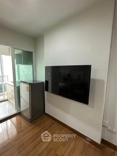 Modern apartment with sleek TV setup and compact kitchen area