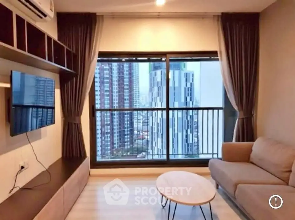 Modern living room with city view, featuring sleek furniture and large windows for natural light.