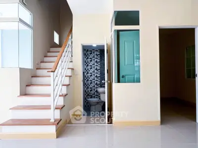 Modern interior with staircase and bathroom, featuring sleek design and neutral tones.