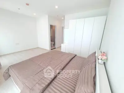 Spacious modern bedroom with elegant decor and ample natural light