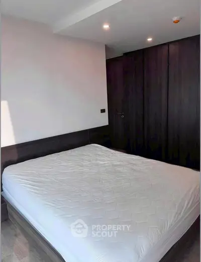 Spacious bedroom with modern dark wood wardrobe and cozy lighting