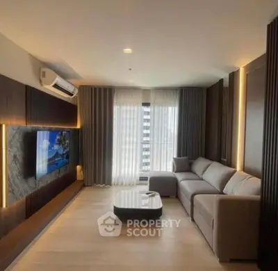 Modern living room with sleek design, large sofa, and wall-mounted TV in a stylish apartment.