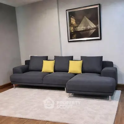 Modern living room with stylish gray sofa and elegant wall art