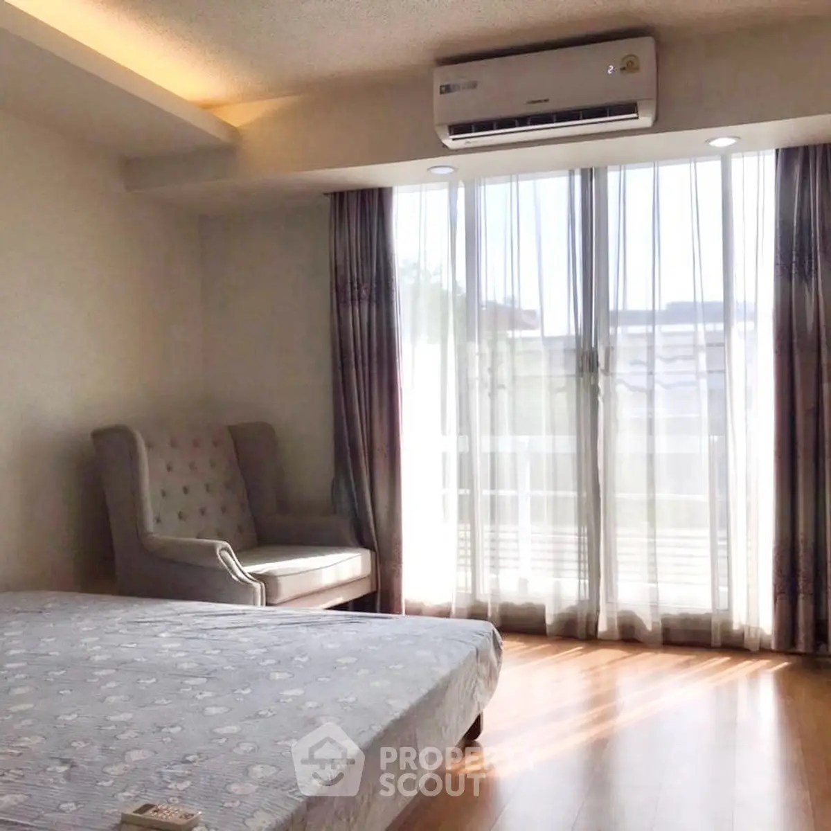 Bright bedroom with large window and elegant armchair