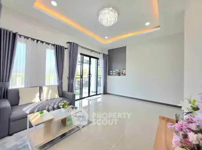 Spacious modern living room with elegant chandelier and large windows for natural light.