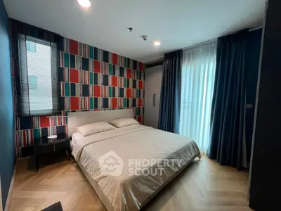 Modern bedroom with stylish wallpaper and large window in a contemporary apartment.