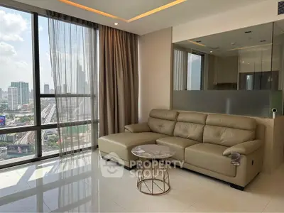 Modern living room with city view, featuring a leather sofa and floor-to-ceiling windows.