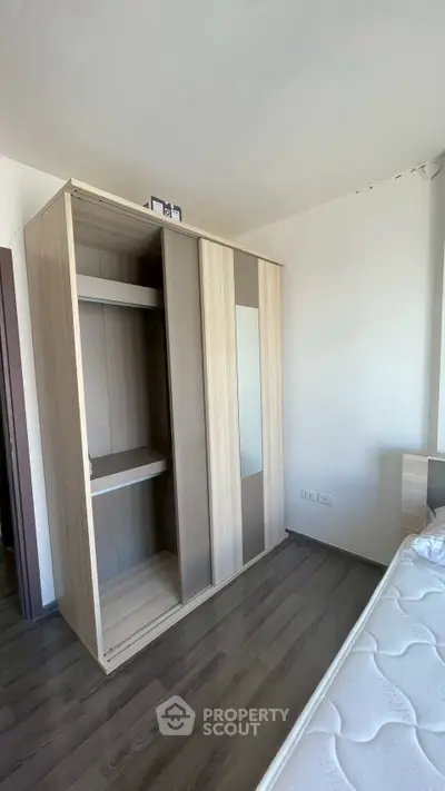 Spacious bedroom with modern wardrobe and comfortable bed, perfect for relaxation and storage.