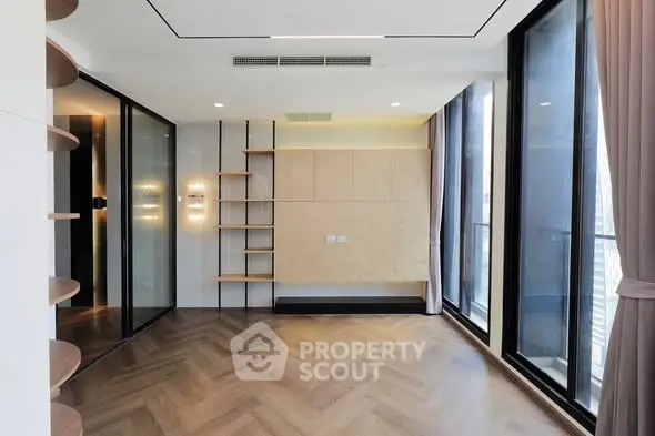 Modern empty living room with large windows and wooden flooring