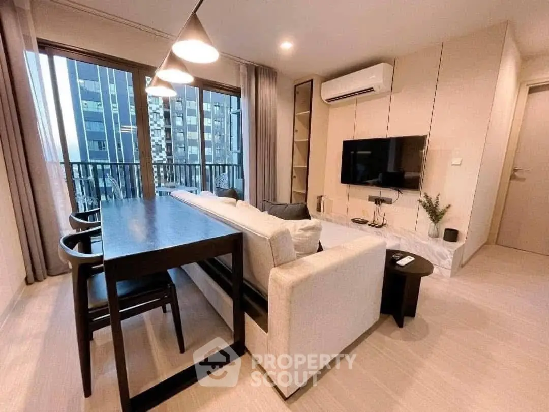 Modern living room with sleek furniture and city view balcony in luxury apartment.