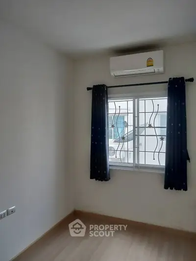 Minimalist bedroom with air conditioning and window view
