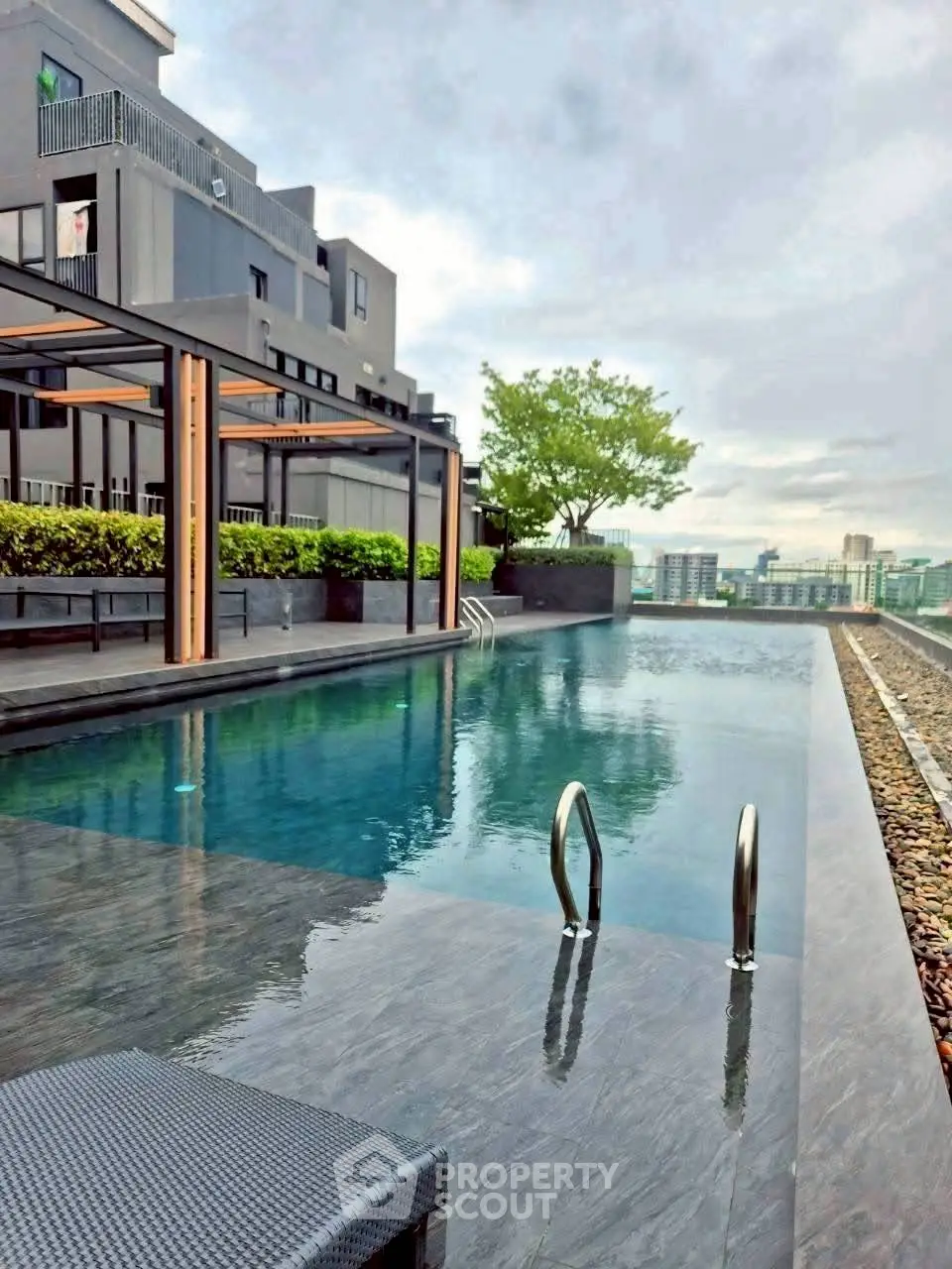 Luxurious rooftop infinity pool with stunning city views in modern residential complex.