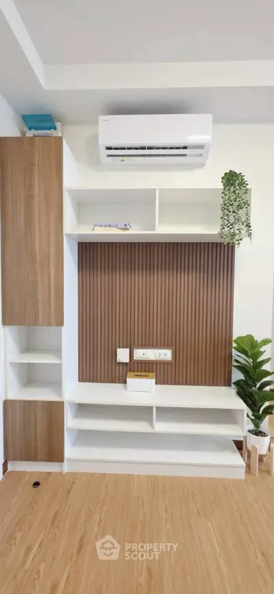 Modern living room with stylish wooden shelving and air conditioning unit, perfect for contemporary homes.