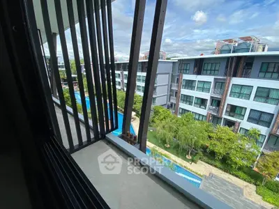Modern apartment balcony with pool and garden view in urban setting