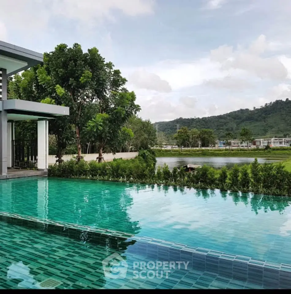 Luxurious infinity pool with scenic mountain and lake views in a modern residential complex.