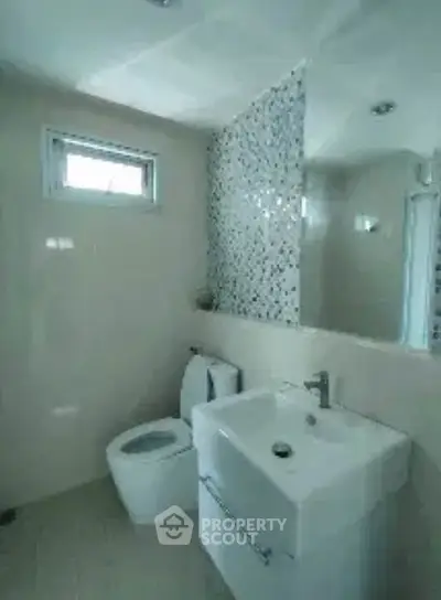 Modern bathroom with sleek fixtures and mosaic tile accent wall