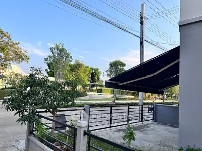 Modern residential exterior with sleek fence and lush greenery