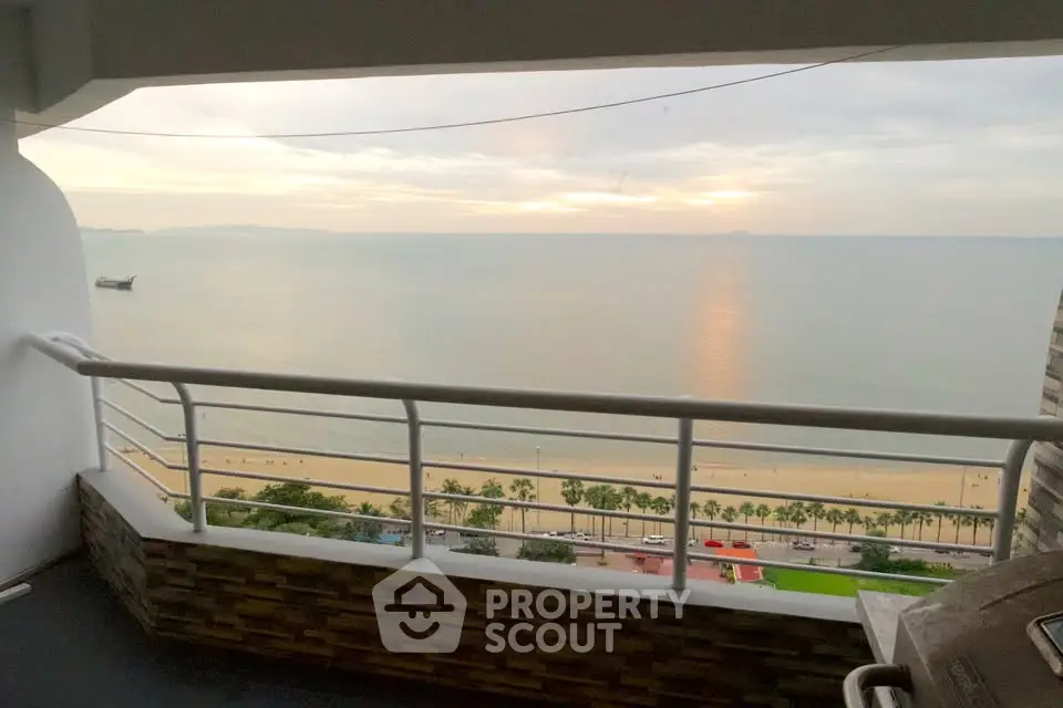 Stunning beachfront balcony with panoramic ocean view at sunset.